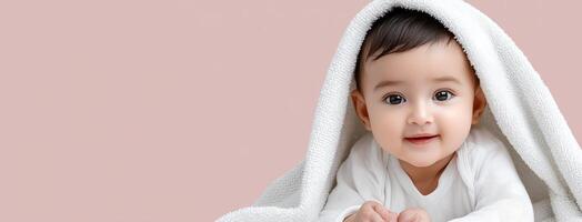 A baby is wrapped in a blanket and smiling photo