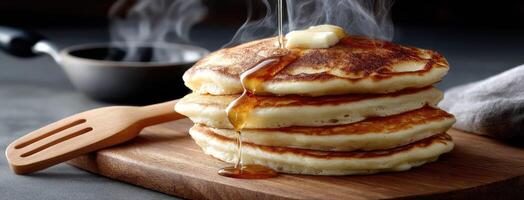 A stack of pancakes with syrup being poured on top photo