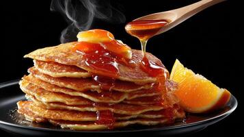 A stack of pancakes with syrup and orange slices photo