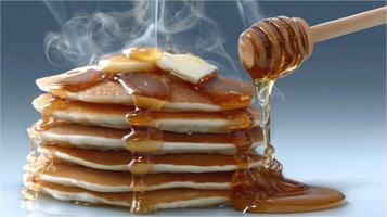 A stack of pancakes with syrup and honey drizzled on top photo