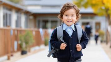 A young boy in a school uniform walking down a sidewalk photo