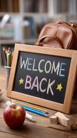 Back to school concept with chalkboard welcome back sign and school supplies on wooden table photo