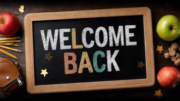 Welcome back sign with apples, pencils, and backpacks photo