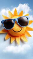 A smiling sun with blue sunglasses on a blue sky photo