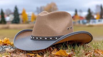 A cowboy hat laying on the ground in the fall photo