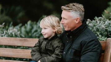 A man and a young boy sitting on a bench photo