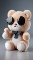 A teddy bear wearing sunglasses and a bow tie photo