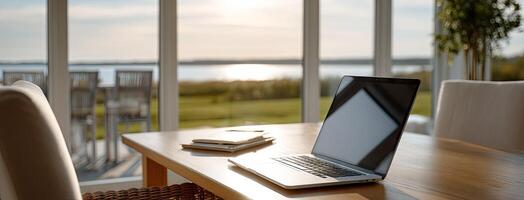 A laptop sitting on a table near a window photo