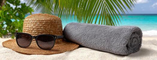 A hat, sunglasses and towel on the beach photo
