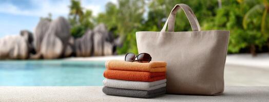 A beach towel, sunglasses and a bag sitting on the sand photo
