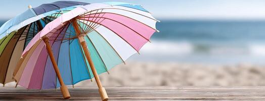 Two colorful umbrellas on a wooden table near the ocean photo