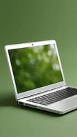 A laptop computer on a green surface photo