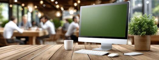 A computer monitor on a wooden table with a plant photo