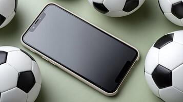A smartphone is surrounded by soccer balls photo