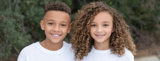 Two young children with curly hair posing for a photo