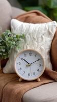 A clock on a couch with a pillow photo
