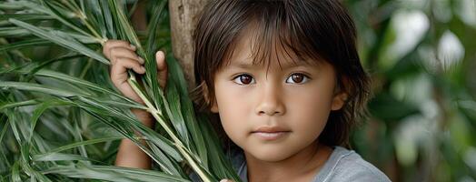 A young child is holding a leaf in front of her face photo