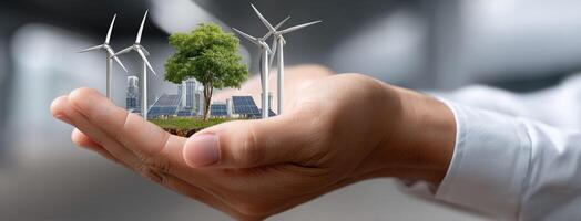Wind turbines and tree in hands concept photo