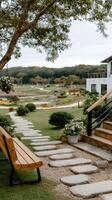 A bench and steps leading to a house and golf course photo