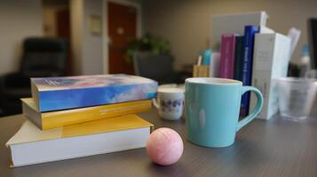 Cozy workspace featuring books, a colorful mug, and a playful ball in an office environment photo