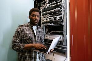 Young technician working on network server in data center during afternoon photo