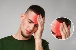 Man experiencing headache with visible discomfort in an indoor setting during daylight hours photo