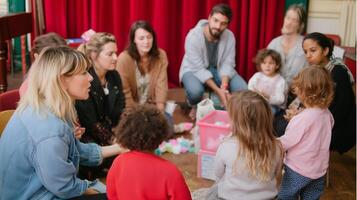 Group of adults and children engaged in creative activities in a community space during a daytime gathering photo