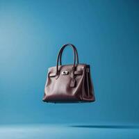 Luxurious brown leather handbag floating against a blue background showcasing elegance and style photo