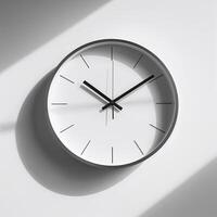 Modern wall clock displaying twelve o'clock against a minimalist white background with shadows photo