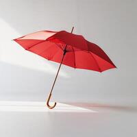 Bright red umbrella stands gracefully against a minimalist background in soft light photo