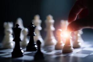 Hand moving chess piece on a board in a dimly lit setting highlighting strategic gameplay and focus on a critical moment photo