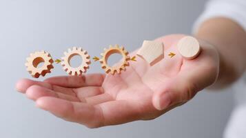 Wooden gears and shape transition depicted on a hand emphasizing creativity and innovation in design photo