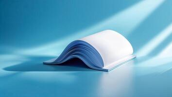 Open book with blue pages resting on a blue surface illuminated by soft light in a minimalist setting photo