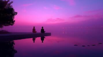 Meditation at dawn by the lake surrounded by mist and colorful sky reflecting calmness and tranquility photo