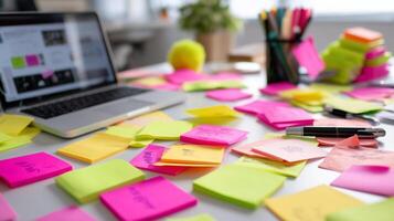 Creative workspace filled with colorful sticky notes and a laptop during a brainstorming session photo