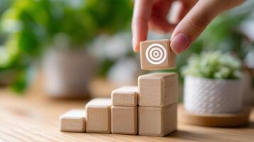 Building blocks stacked on a table with a person placing a target block in a bright indoor space photo