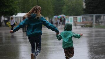 Children playfully running through rain in a public park during a light drizzle on a cloudy day photo