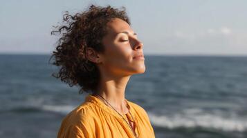 Woman enjoying peaceful moment at seaside during sunset while practicing mindfulness and relaxation techniques photo