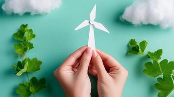 Creating a simple paper wind turbine model with green leaves on a light blue background photo