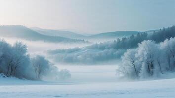 Frosty winter landscape with mist over rolling hills and frozen trees in early morning light photo