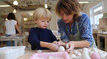 Child learns pottery skills from instructor in a creative studio during a clay workshop photo