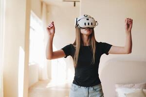 Woman experiencing virtual reality in a bright room during daylight hours while engaging in an interactive digital environment photo