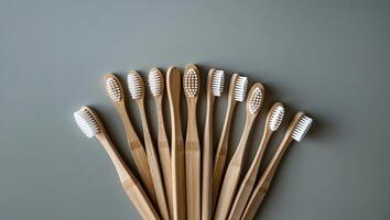 Collection of eco-friendly bamboo toothbrushes arranged in a neat pattern on a gray surface photo