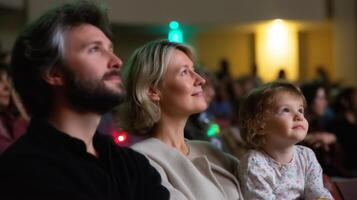 Family enjoys a captivating performance together in a theater during an evening event photo