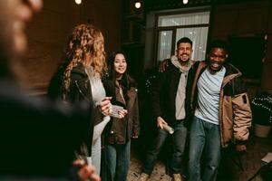 Group of friends enjoying a joyful evening gathering indoors at a cozy location with soft lighting and laughter photo