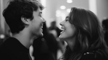 Young couple sharing a joyful moment while laughing together in a busy indoor space during the evening hours photo