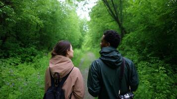 Couple walking on a lush green trail surrounded by vibrant foliage during a sunny afternoon in a peaceful forest photo