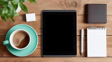 Relaxing workspace setup with coffee, tablet, and notepad on wooden table photo