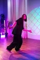 Dancer showcasing contemporary moves in colorful studio setting during evening performance photo