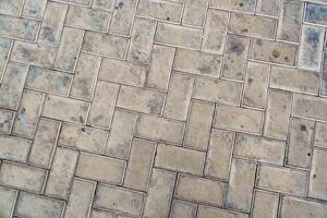 Detailed view of textured paving stones in a city setting highlighting their unique patterns and wear marks photo